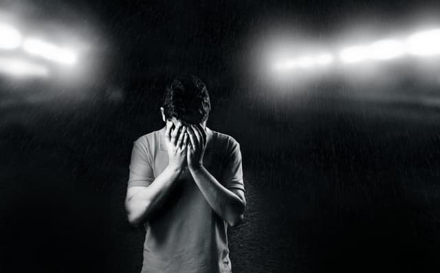 man with his hands in the face crying